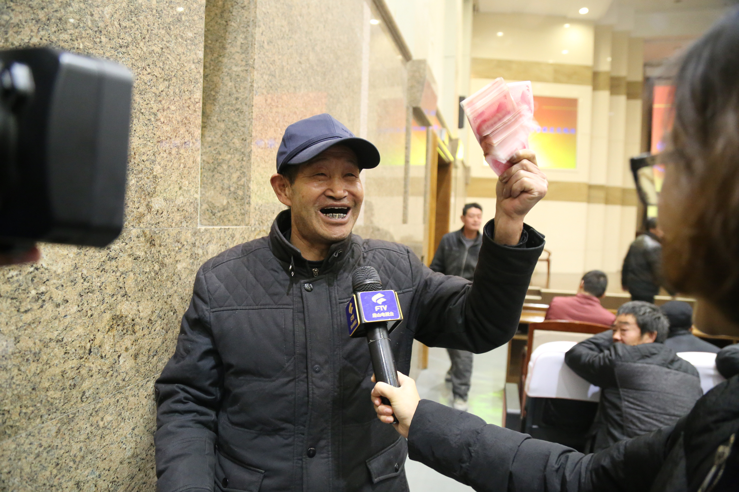 领到钱的农民工在接受记者采访