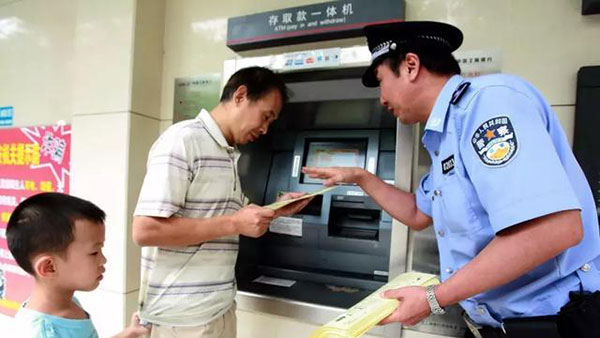 民警在辖区某银行向居民讲解电话诈骗的手段
